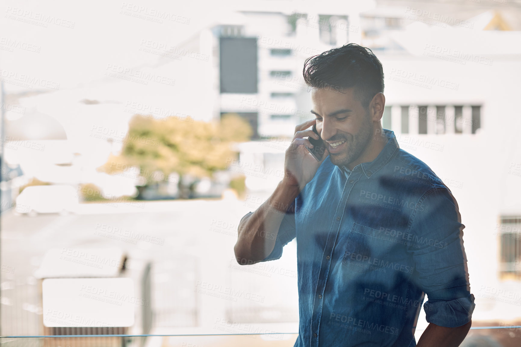 Buy stock photo Professional businessman smiling on phone call, in modern office. Charming, confident casual employee, holding cellphone and talking during mobile conversation. Worker standing outdoors in workplace