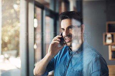 Buy stock photo Shot of a young man using a mobile phone to make a call in a modern office