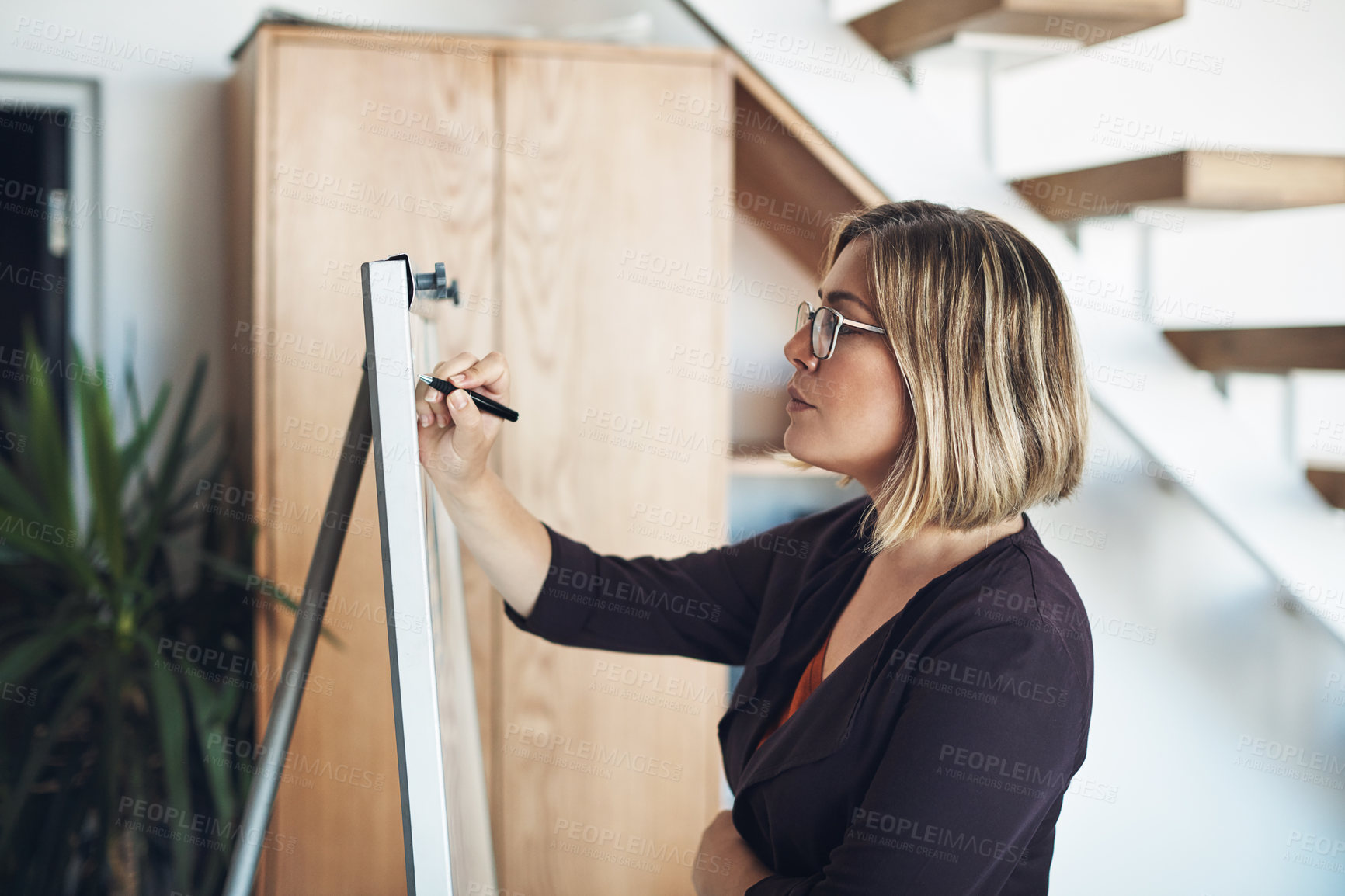 Buy stock photo Planning strategy, thinking and writing ideas on whiteboard to market, promote and advertise new startup company. Confident, serious and assertive business woman, manager and boss finding a solution