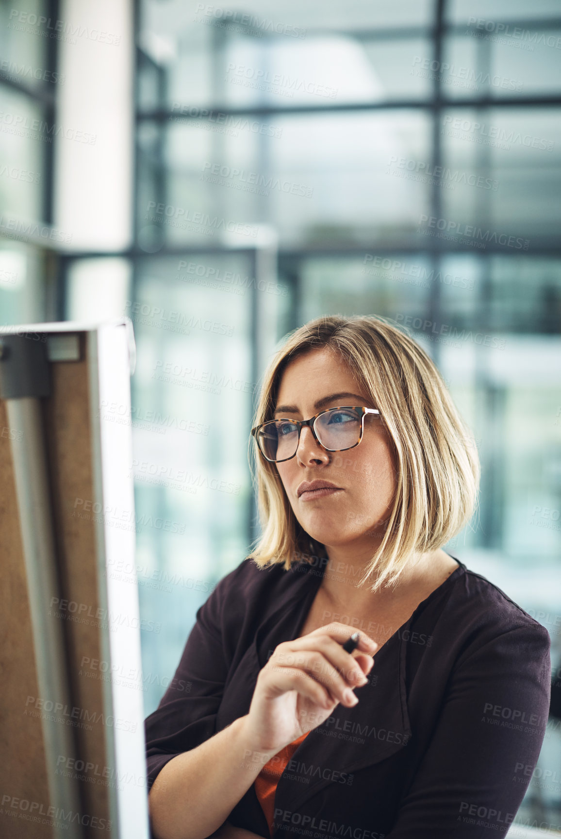 Buy stock photo Businesswoman thinking, planning and brainstorming while looking thoughtful and writing ideas on an office whiteboard. Female entrepreneur working on a plan and strategy to achieve marketing success