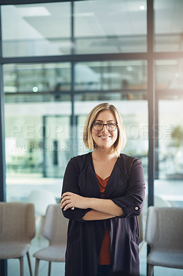 Buy stock photo Proud, arms crossed and confident businesswoman standing alone in a modern office. Young female business owner smiling in a corporate workplace. Happy and successful lady at work with copy space.