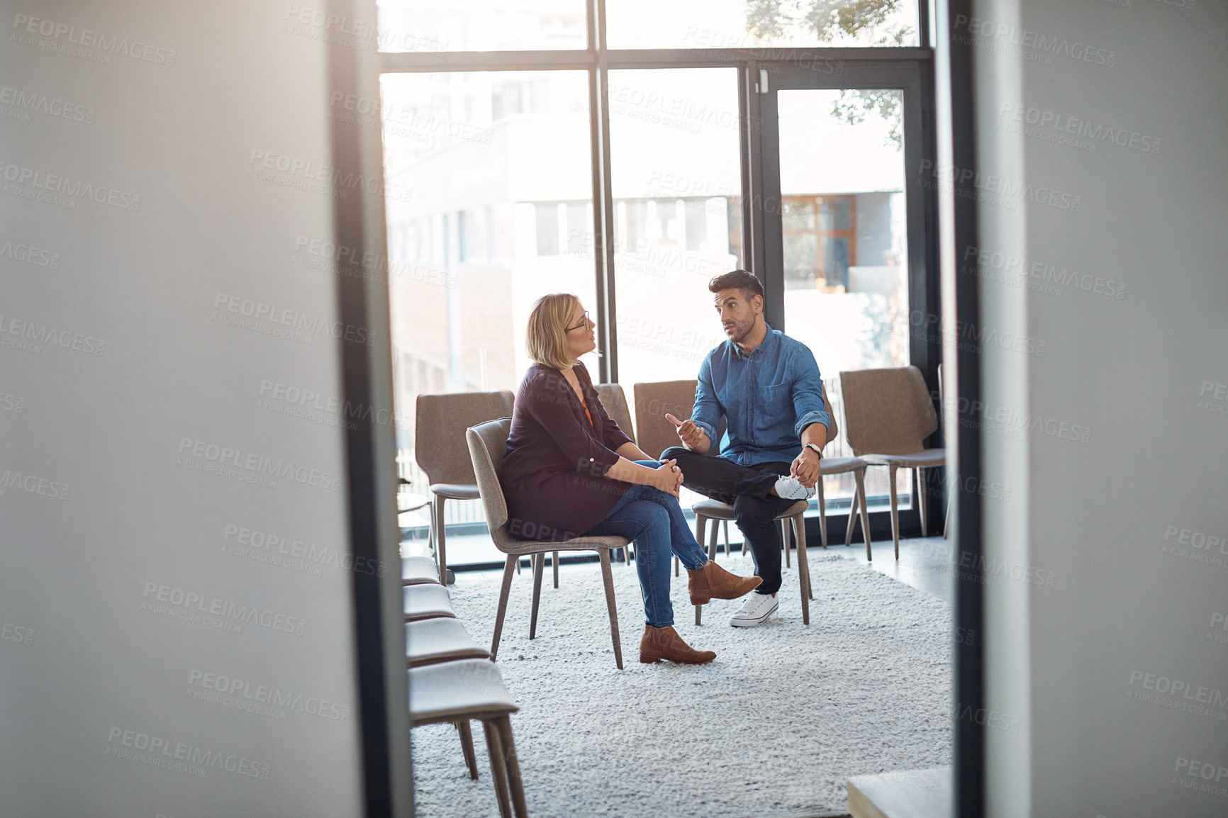 Buy stock photo Business man in a job interview with a businesswoman talking about hiring and recruitment. An HR manager and employee sitting and having a discussion or meeting in a modern office or workplace