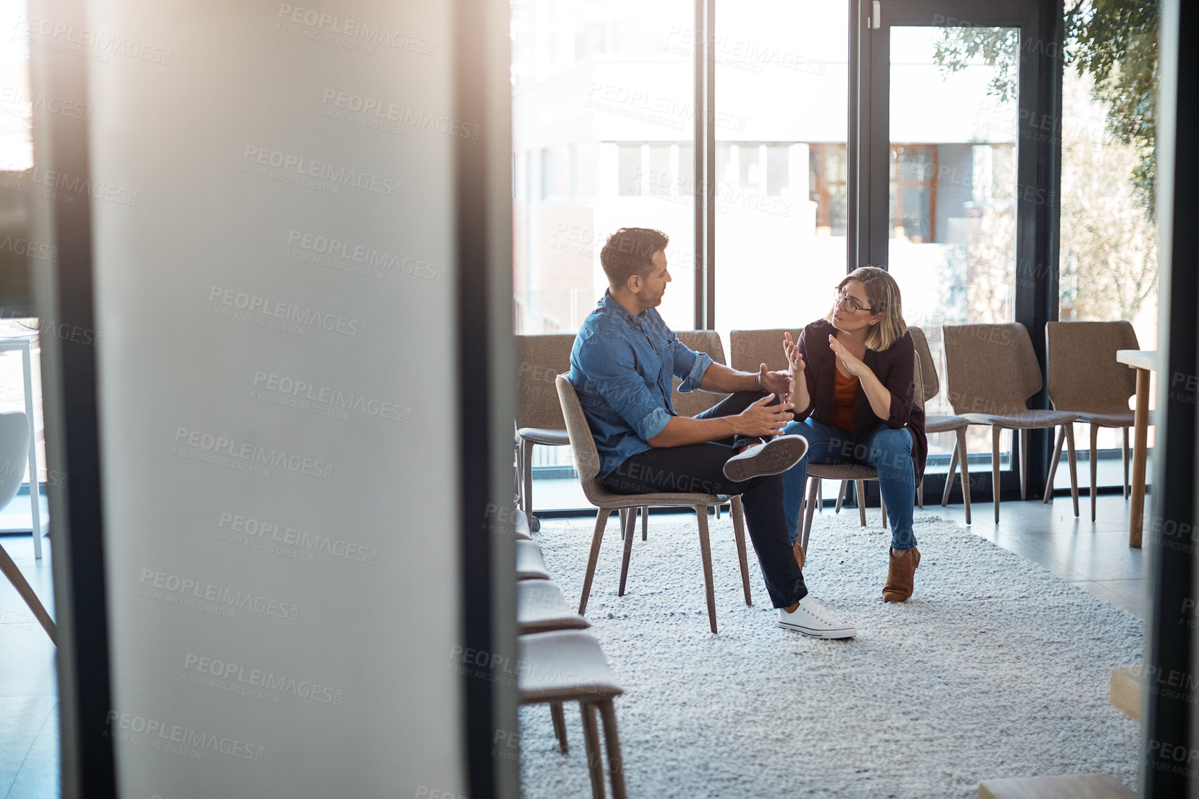 Buy stock photo Talking, planning or meeting team of colleagues brainstorming ideas, discussing strategy and sharing plans in office. Confident and serious business woman discussing and explaining to male coworker