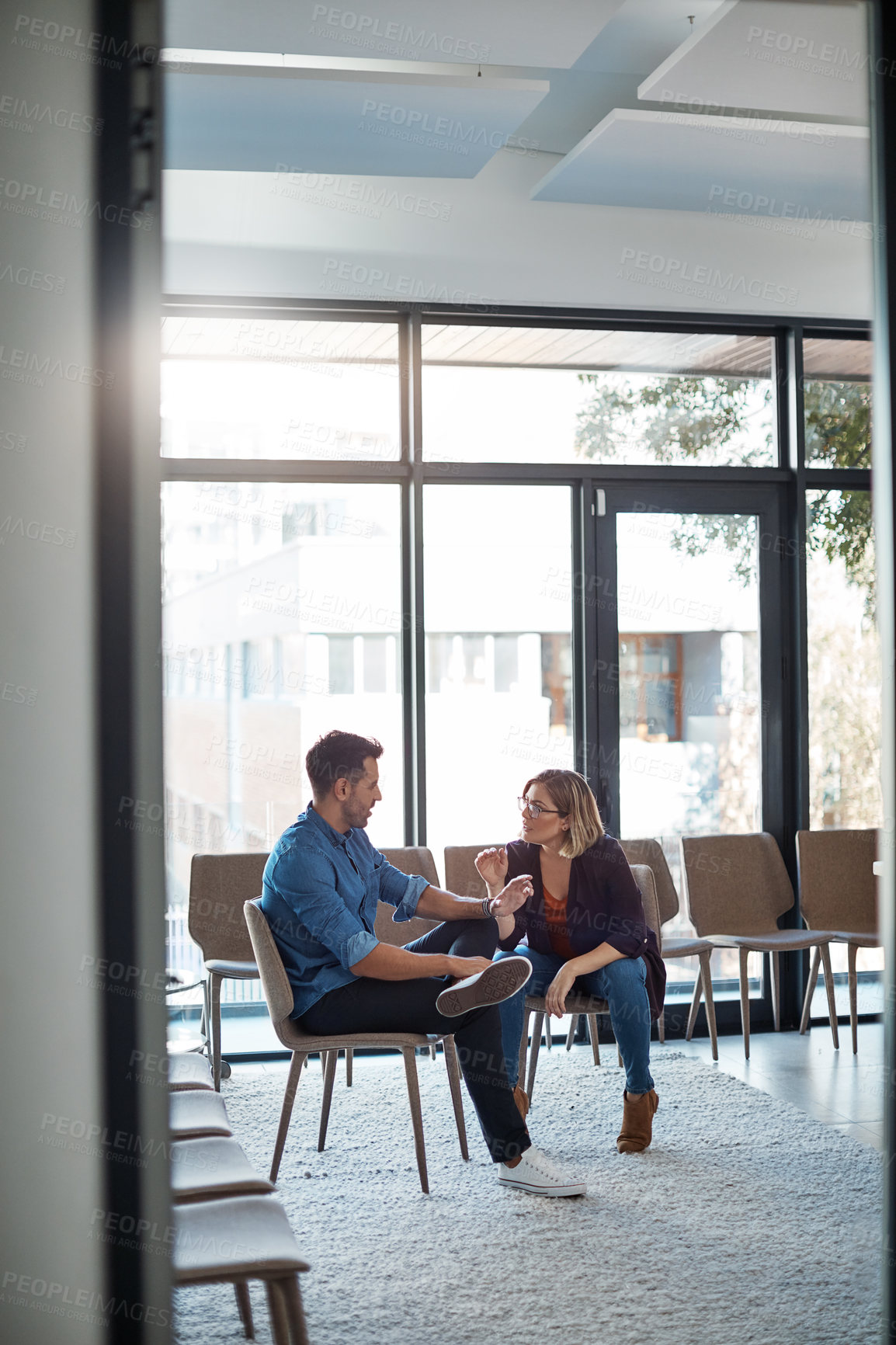 Buy stock photo Serious, professional business woman talking to work colleague in modern startup office. Manager having casual conversation with male employee. Coworkers meeting and discussing plans for a project 