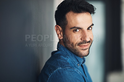 Buy stock photo Portrait of confident and casual man leaning against a grey wall looking happy, proud and glad while smiling. Face of stylish, handsome and young european male standing alone inside with copy space