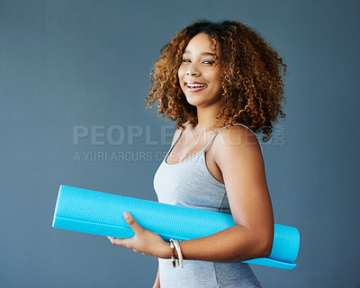 Buy stock photo Cropped shot of a young woman holding a yoga mat against a grey background