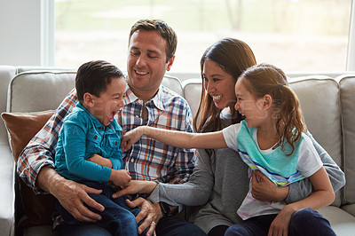 Buy stock photo Tickle, kids and happy family in home with parents together for care, love and bonding. Children, mother and father on sofa for support, relax and playing with funny siblings laughing in living room