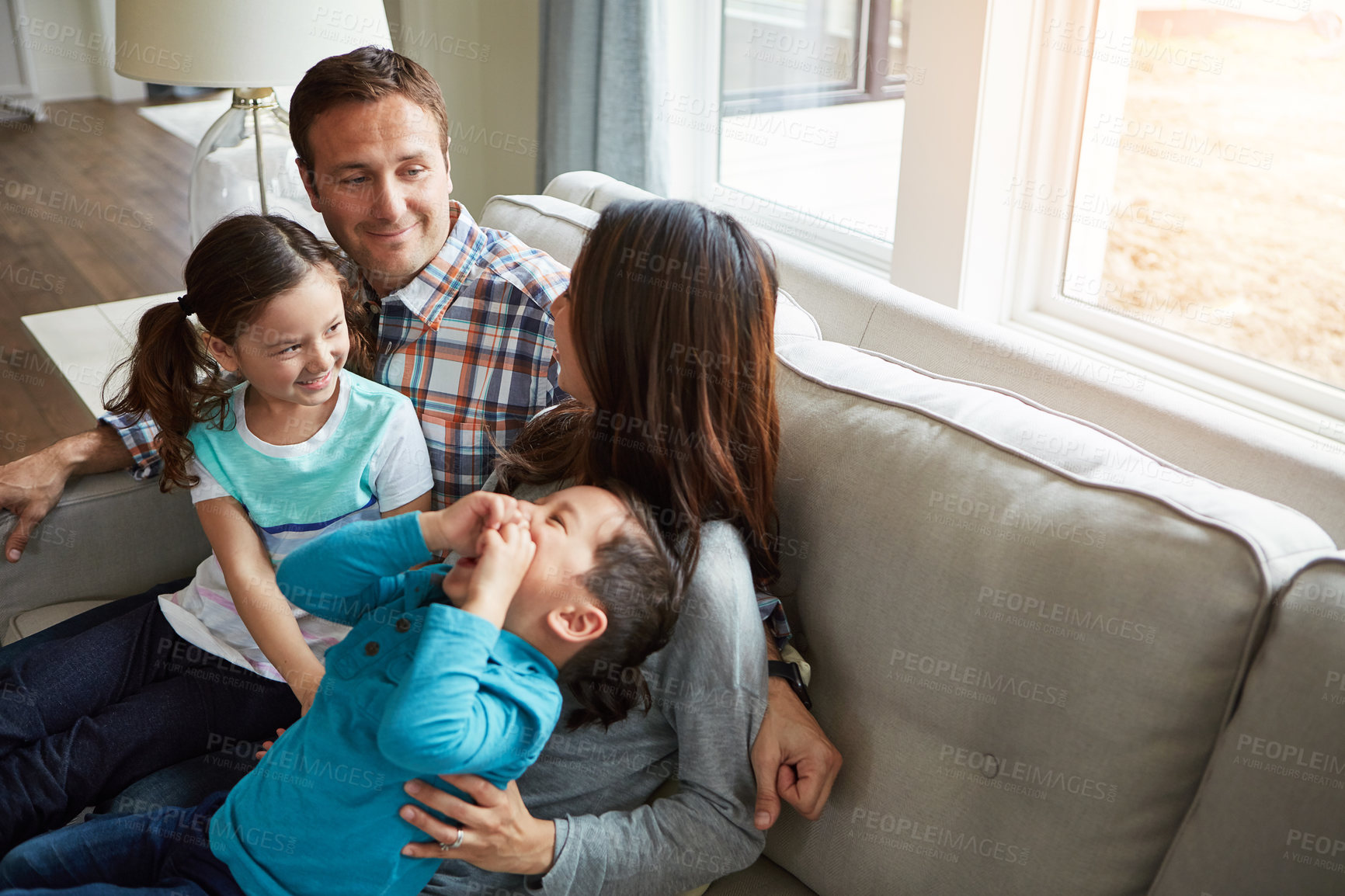 Buy stock photo Relax, children and happy family in home with parents together for care, love or bonding. Kids, mother and father on sofa for support, conversation and play with funny siblings laughing in top view