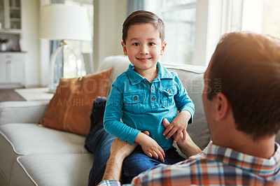 Buy stock photo Shot of an adorable little boy and his father playing together on the sofa at home