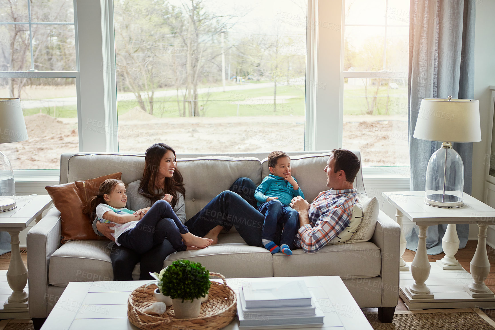 Buy stock photo Relax, children and happy family in home with parents together for care, love or bonding. Kids, mother and father on sofa for support, talking or playing with funny siblings laughing in living room