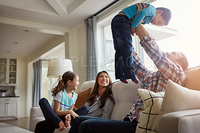 Buy stock photo Shot of a happy young family of four bonding together on the sofa at home