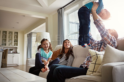 Buy stock photo Shot of a happy young family of four bonding together on the sofa at home