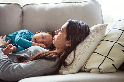 Buy stock photo Shot of a young woman and her son relaxing together on the sofa at home