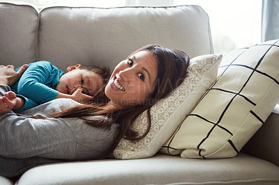 Buy stock photo Shot of a young woman and her son relaxing together on the sofa at home