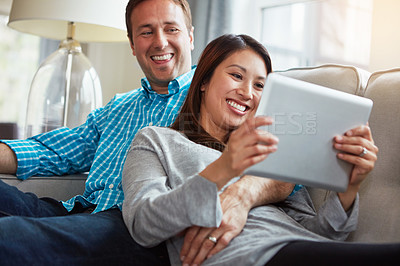 Buy stock photo Tablet, couple and social media on sofa for funny post, scroll internet or relax in living room. Lens flare, online and happy woman with man for entertainment, meme or watching comedy movie in home