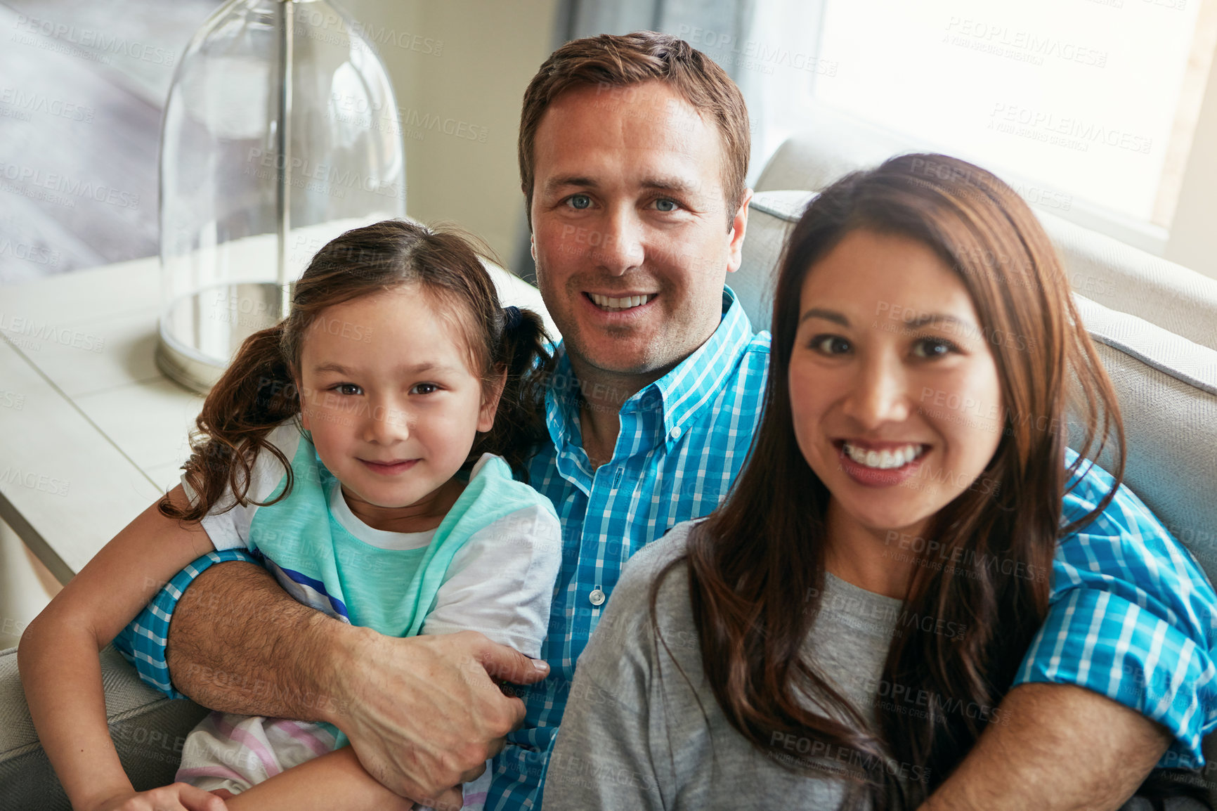 Buy stock photo Portrait, child and happy family in home with parents together for care, love and bonding. Face, mother and father on sofa with kid for support, connection and hug to relax with girl in living room