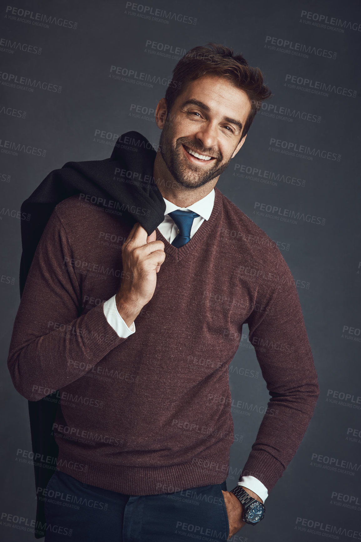 Buy stock photo Studio portrait of a stylishly dressed young man carrying his jacket against a gray background