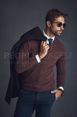 Buy stock photo Studio shot of a stylishly dressed young man carrying his jacket against a gray background