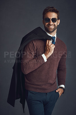 Buy stock photo Studio portrait of a stylishly dressed young man carrying his jacket against a gray background