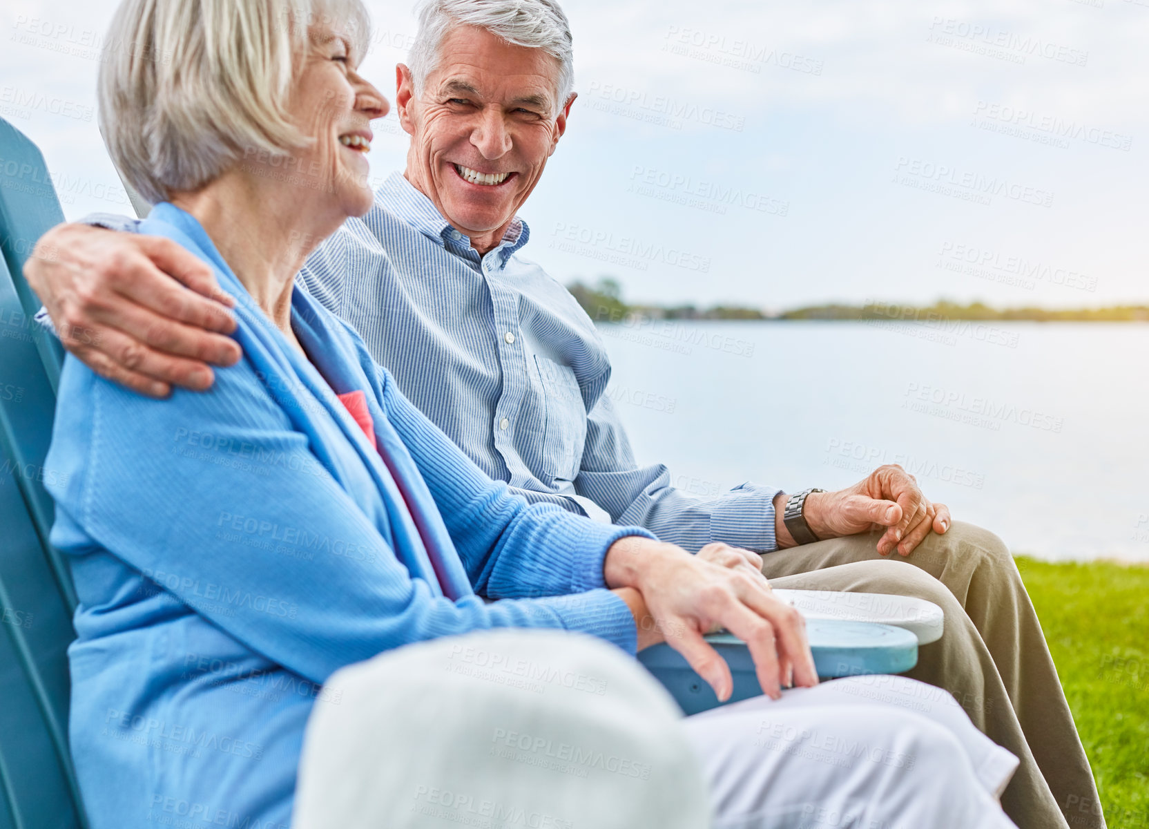 Buy stock photo Shot of an affectionate senior couple relaxing on chairs together outside