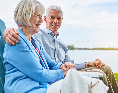 Buy stock photo Portrait of an affectionate senior couple relaxing on chairs together outside