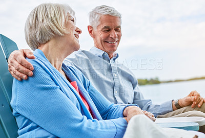 Buy stock photo Shot of an affectionate senior couple relaxing on chairs together outside