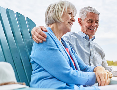 Buy stock photo Shot of an affectionate senior couple relaxing on chairs together outside