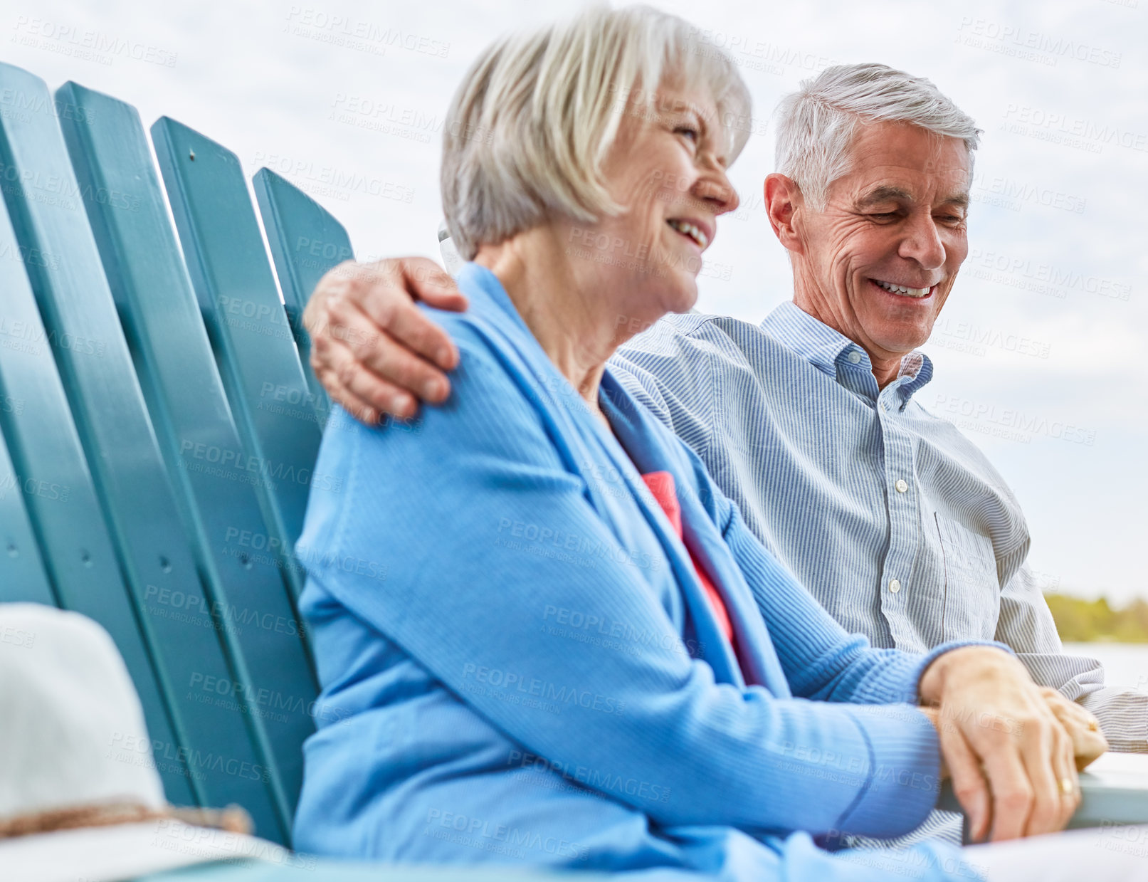 Buy stock photo Shot of an affectionate senior couple relaxing on chairs together outside