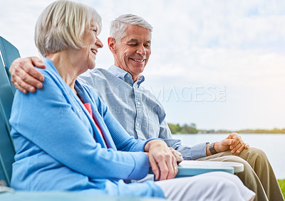 Buy stock photo Shot of an affectionate senior couple relaxing on chairs together outside