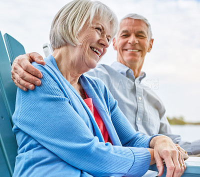 Buy stock photo Shot of an affectionate senior couple relaxing on chairs together outside