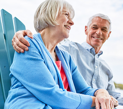 Buy stock photo Shot of an affectionate senior couple relaxing on chairs together outside