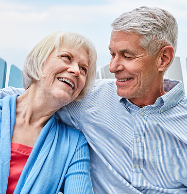 Buy stock photo Shot of an affectionate senior couple relaxing on chairs together outside