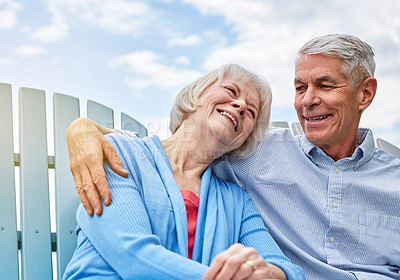 Buy stock photo Shot of an affectionate senior couple relaxing on chairs together outside