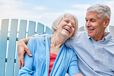 Buy stock photo Shot of an affectionate senior couple relaxing on chairs together outside