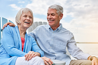 Buy stock photo Shot of an affectionate senior couple relaxing on chairs together outside