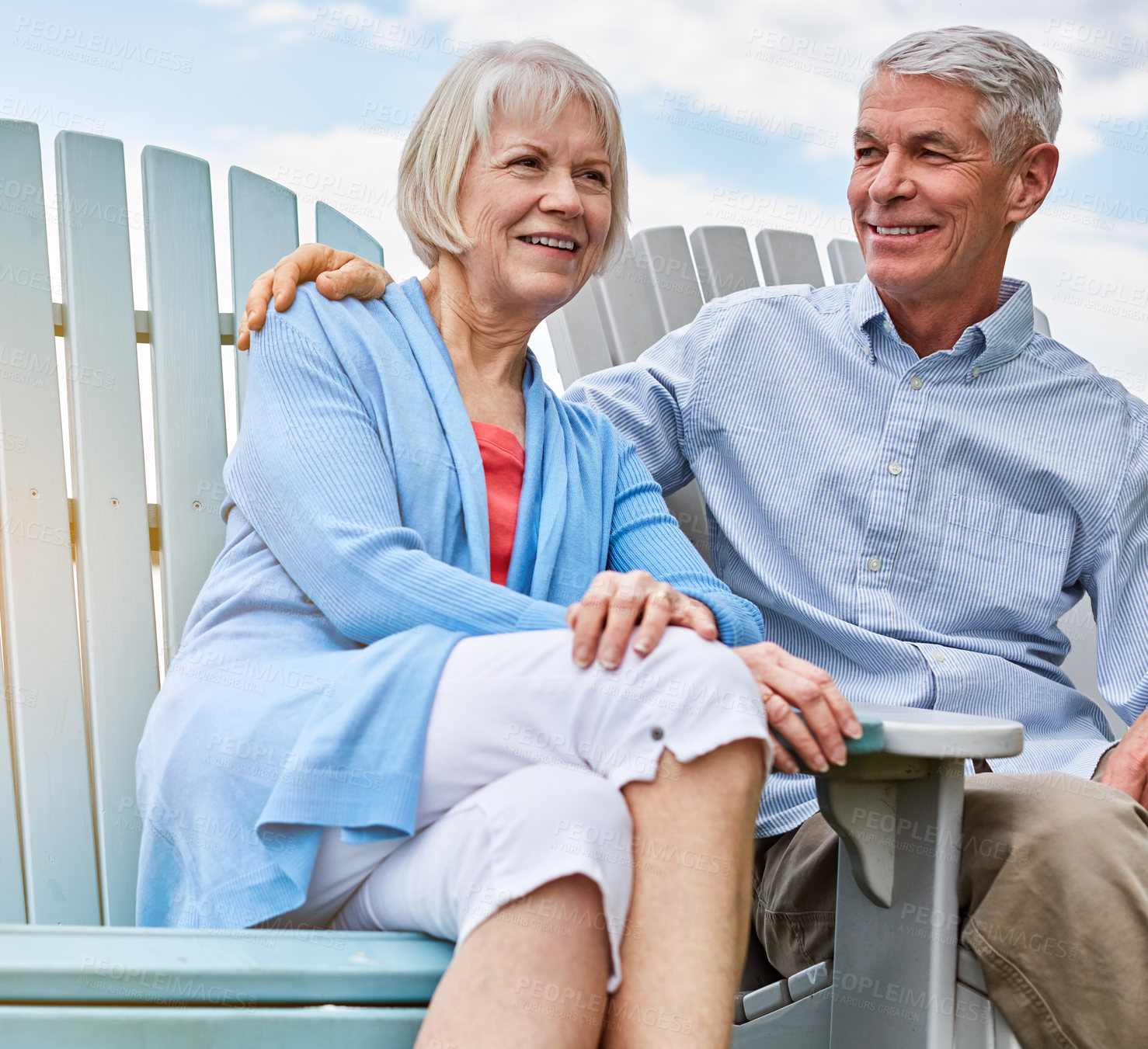 Buy stock photo Shot of an affectionate senior couple relaxing on chairs together outside