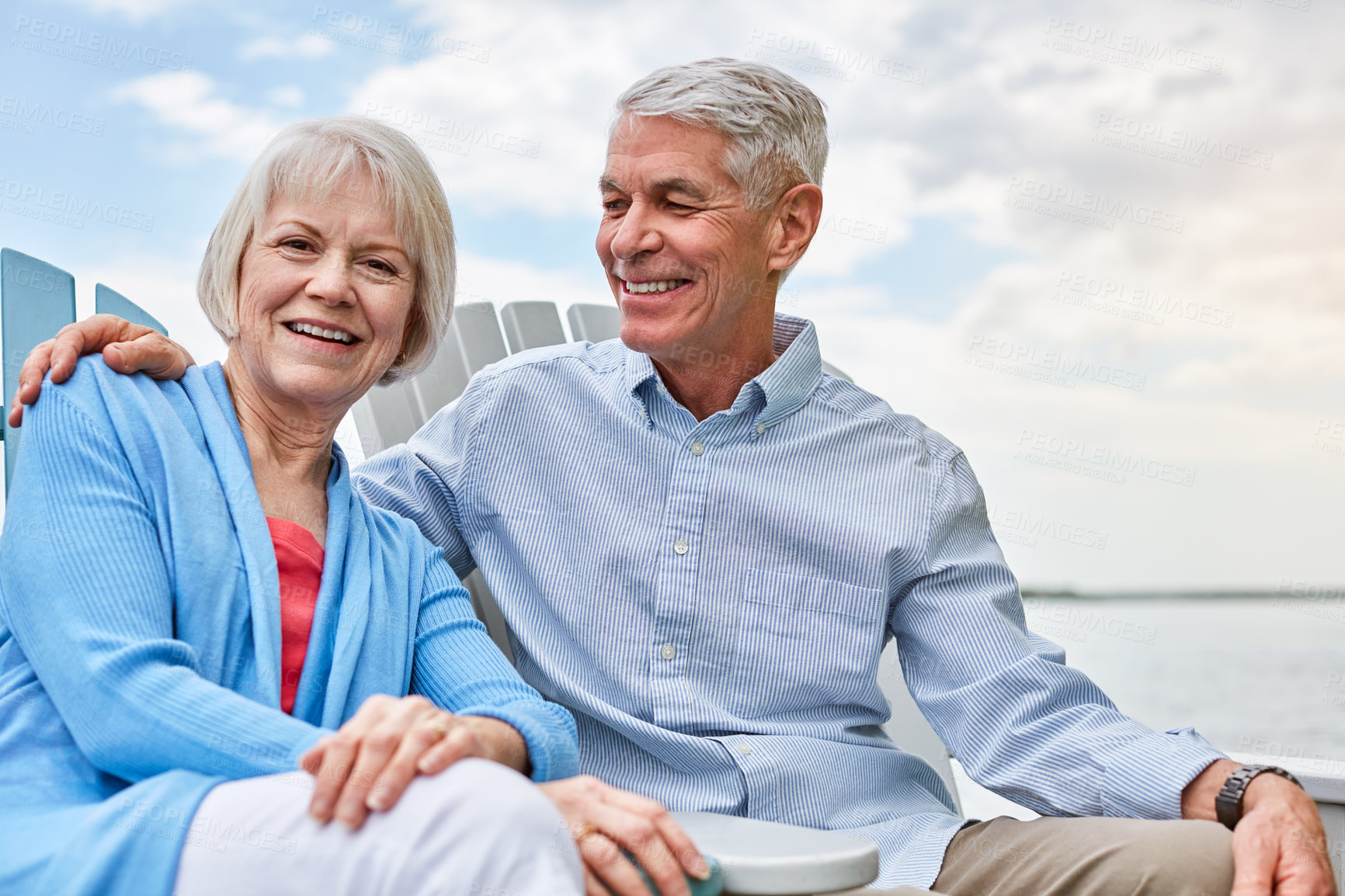 Buy stock photo Portrait of an affectionate senior couple relaxing on chairs together outside