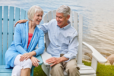 Buy stock photo Shot of an affectionate senior couple relaxing on chairs together outside