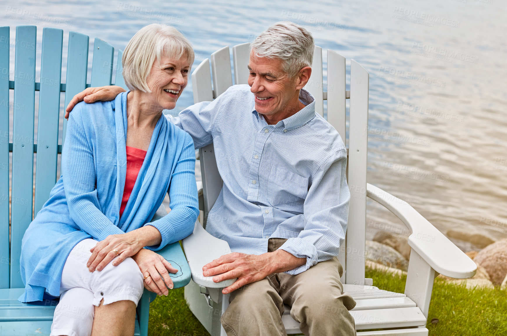 Buy stock photo Shot of an affectionate senior couple relaxing on chairs together outside