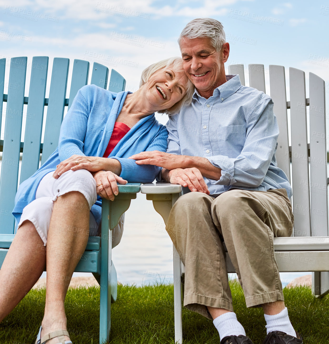 Buy stock photo Shot of an affectionate senior couple relaxing on chairs together outside