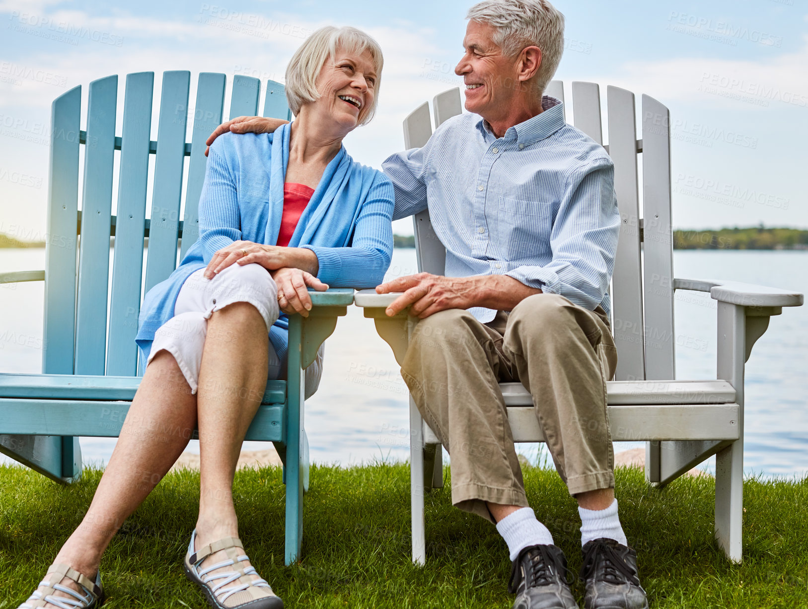 Buy stock photo Shot of an affectionate senior couple relaxing on chairs together outside