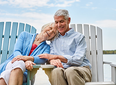 Buy stock photo Shot of an affectionate senior couple relaxing on chairs together outside