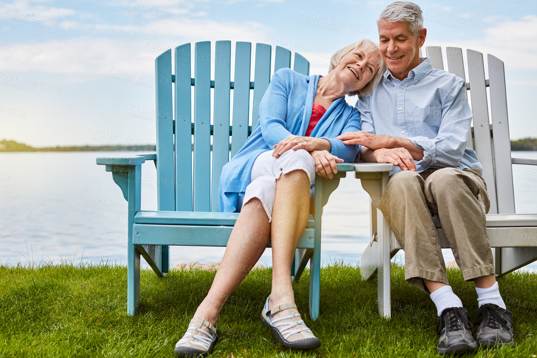 Buy stock photo Shot of an affectionate senior couple relaxing on chairs together outside