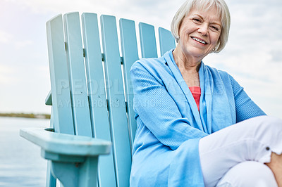 Buy stock photo Portrait of a happy senior woman relaxing on a chair outside