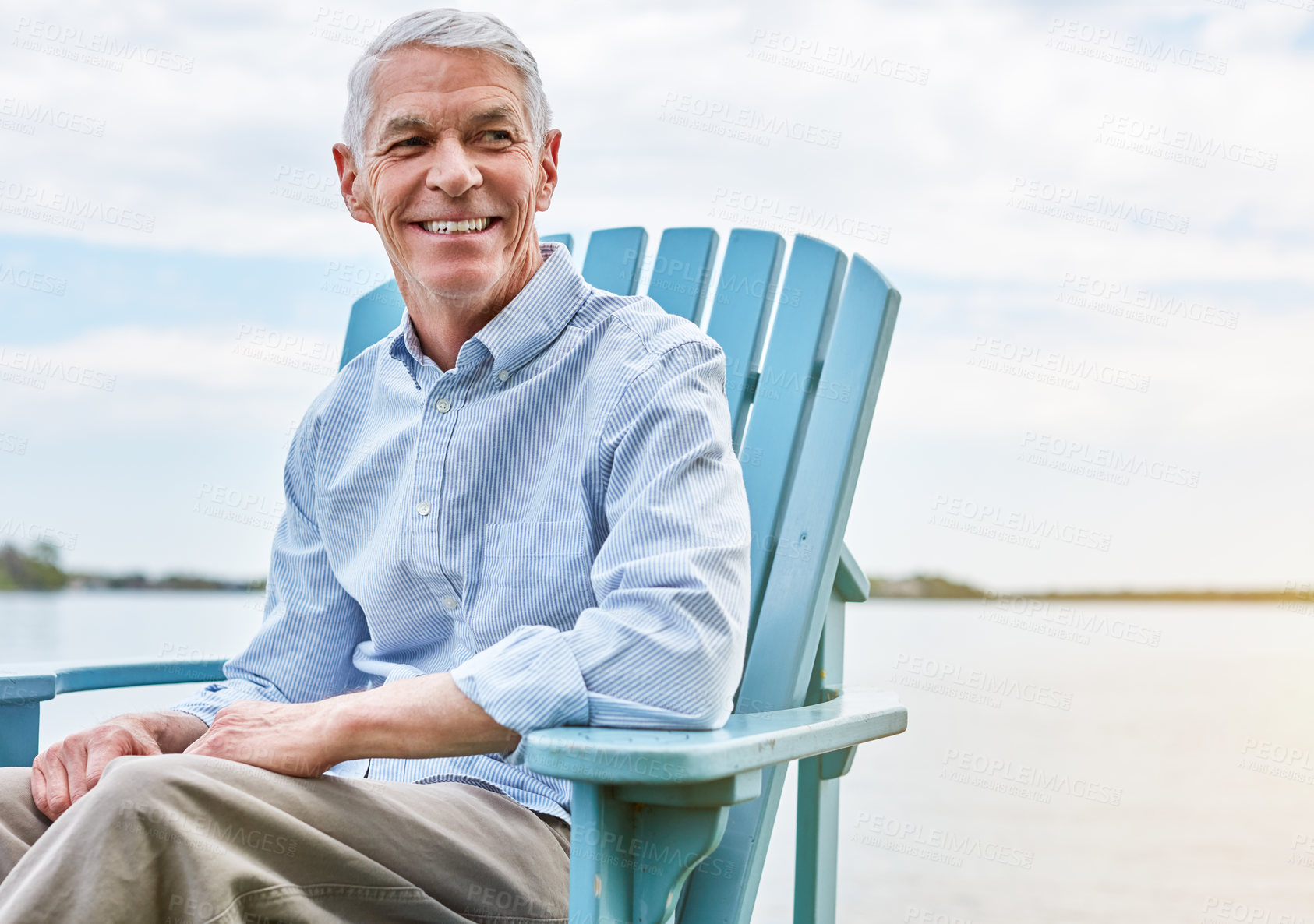 Buy stock photo Shot of a happy senior man relaxing on a chair outside