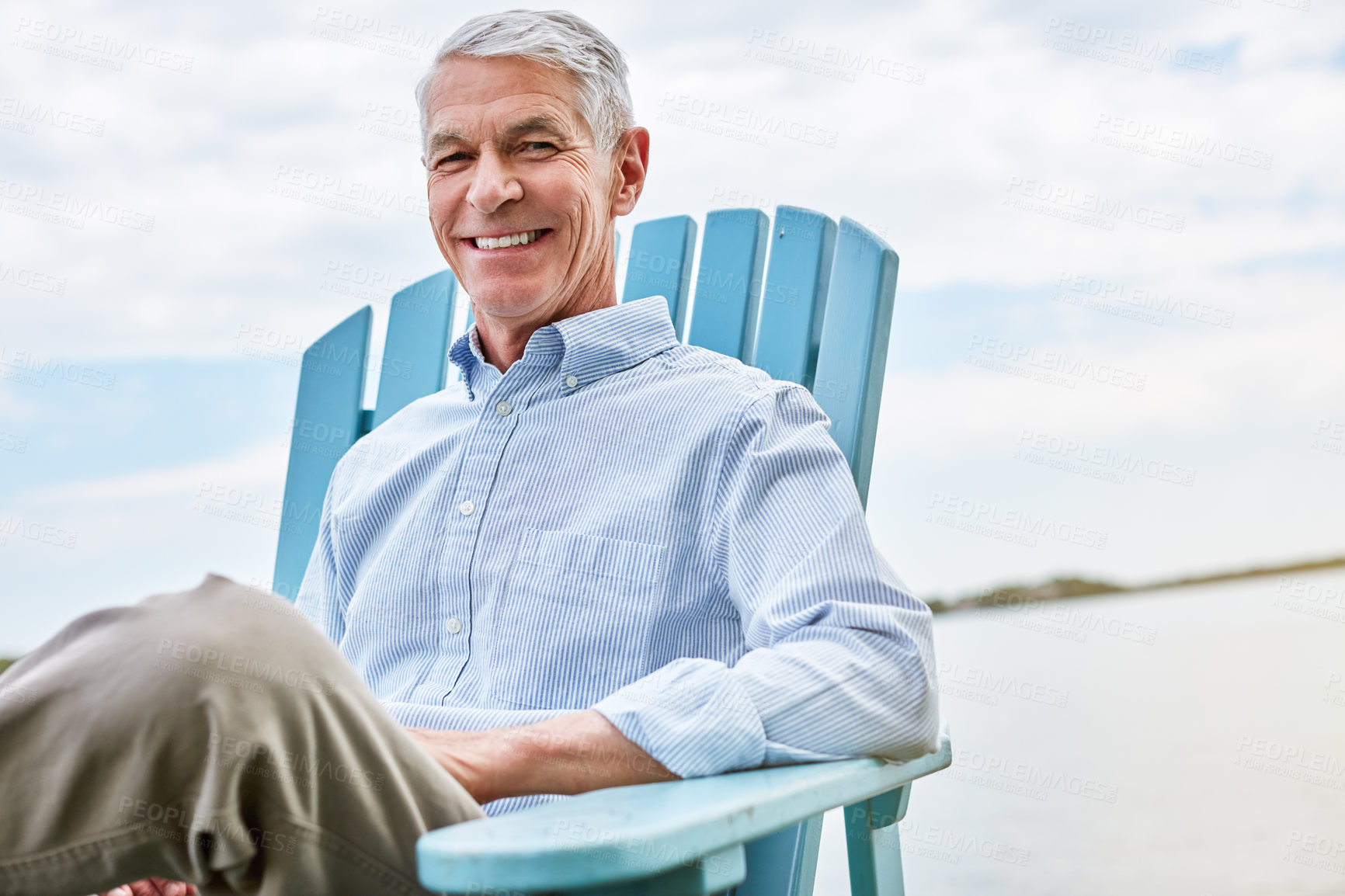 Buy stock photo Portrait of a happy senior man relaxing on a chair outside