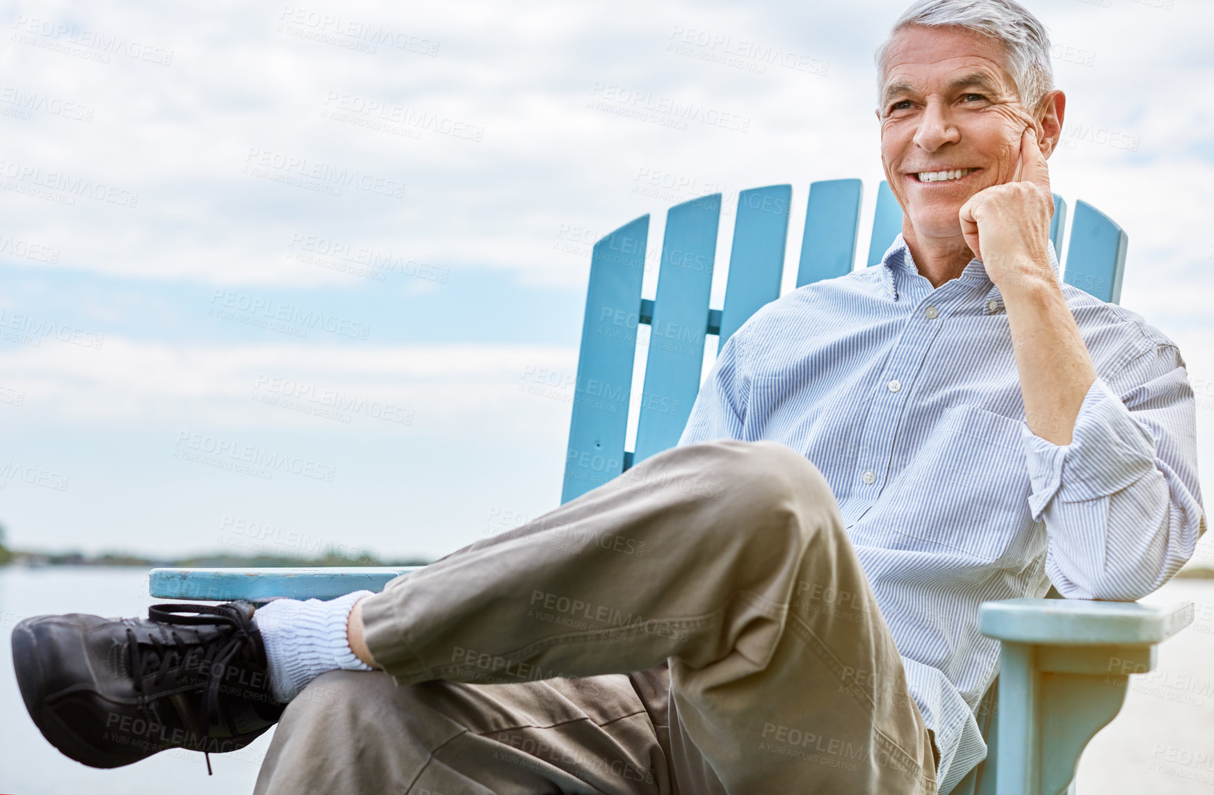 Buy stock photo Shot of a happy senior man relaxing on a chair outside