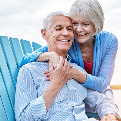 Buy stock photo Shot of an affectionate senior couple relaxing on chairs together outside