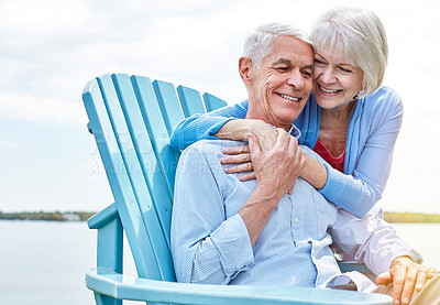 Buy stock photo Shot of an affectionate senior couple relaxing on chairs together outside