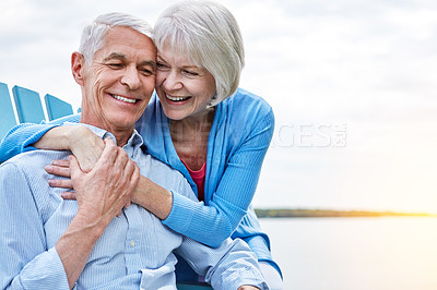 Buy stock photo Shot of an affectionate senior couple relaxing on chairs together outside